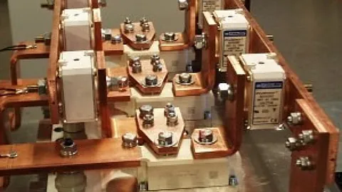 Nærbilde av en elektrisk koblingsenhet med kobberledere og festebolter.