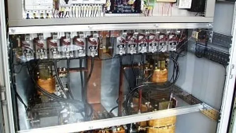 Åpent kontrollskap med elektriske komponenter, kabler og koblinger.